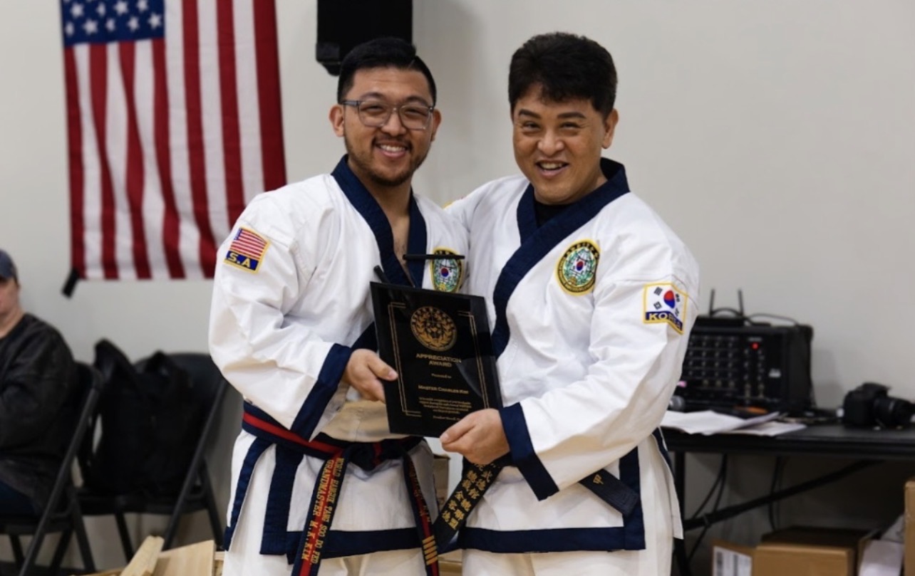 Grandmaster Moon K. Kim presenting an appreciation award to Master Charles Kim